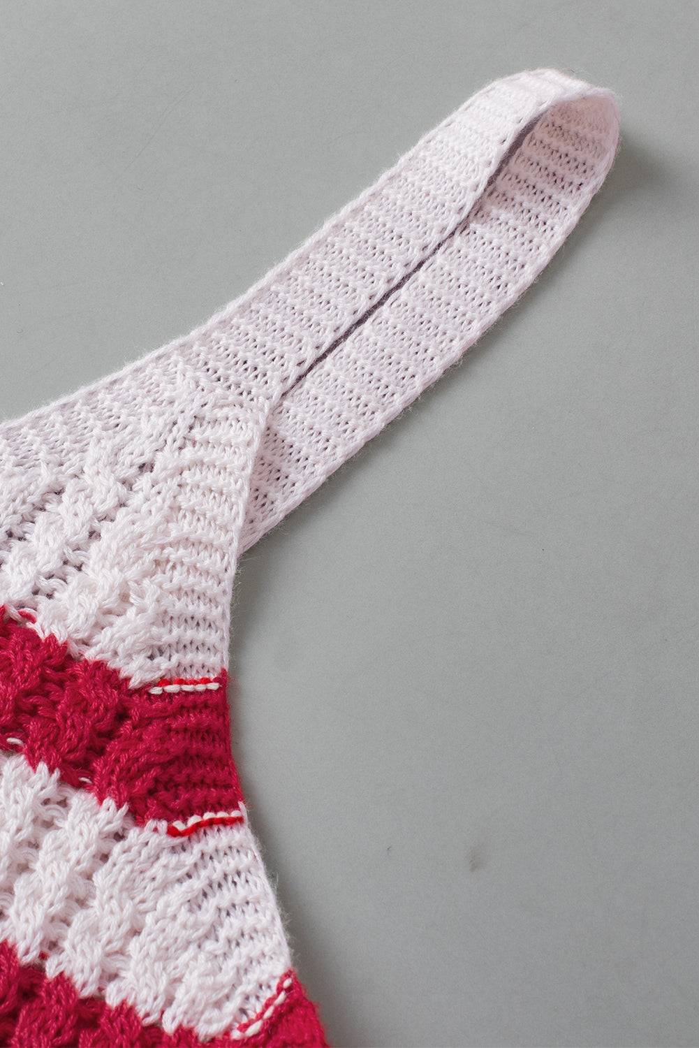 a red and white knitted tie laying on top of a table
