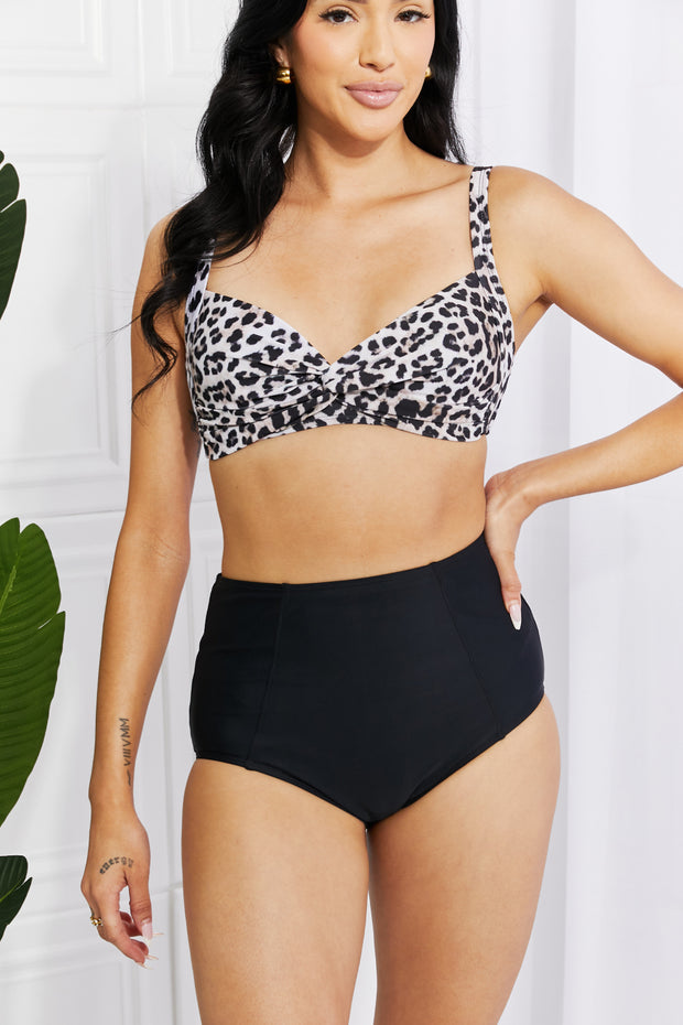 a woman in a leopard print bra top and black high waist shorts