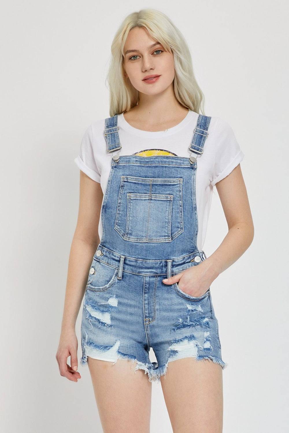 a woman in a white shirt and denim overalls