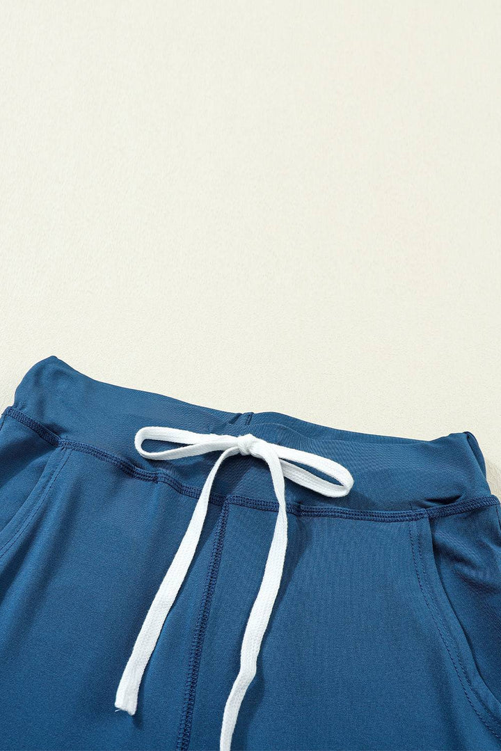 a close up of a blue shorts with a white drawstring