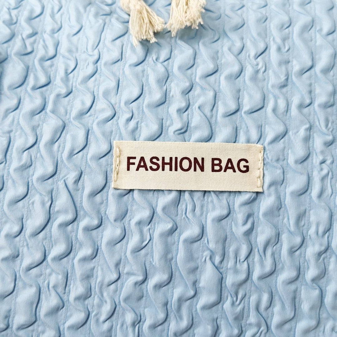 a label that says fashion bag on a blue blanket