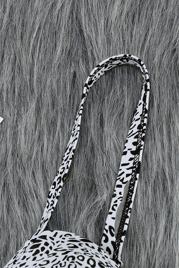 a white and black animal print purse on a furry surface
