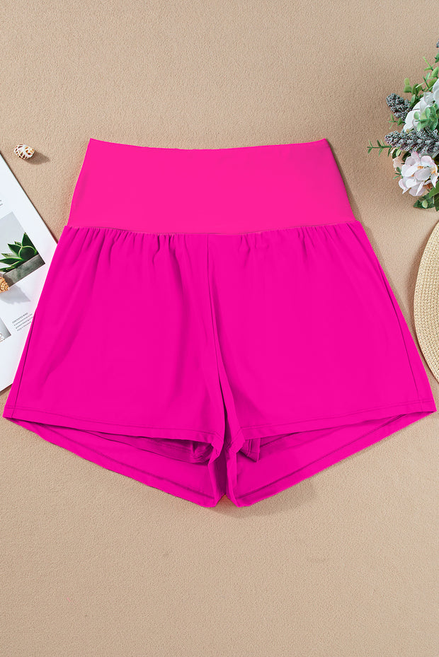 a pair of hot pink shorts next to a plant