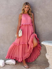 a woman in a pink dress leaning against a wall