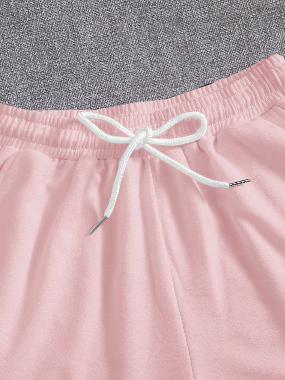 a close up of a pink shorts with a white tie