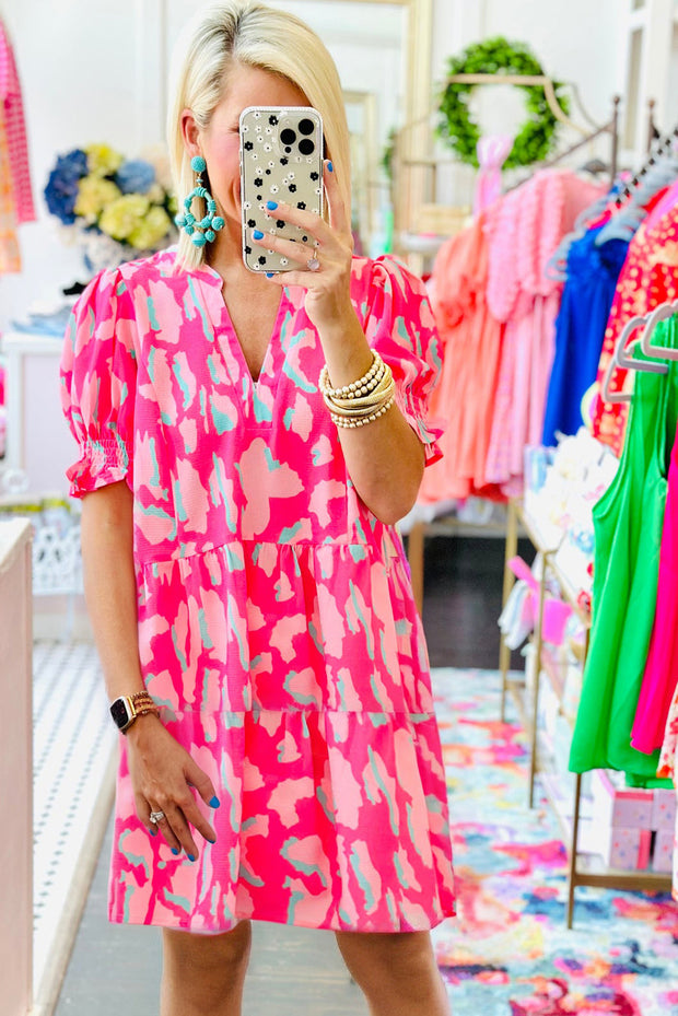 a woman taking a picture of herself in a pink dress