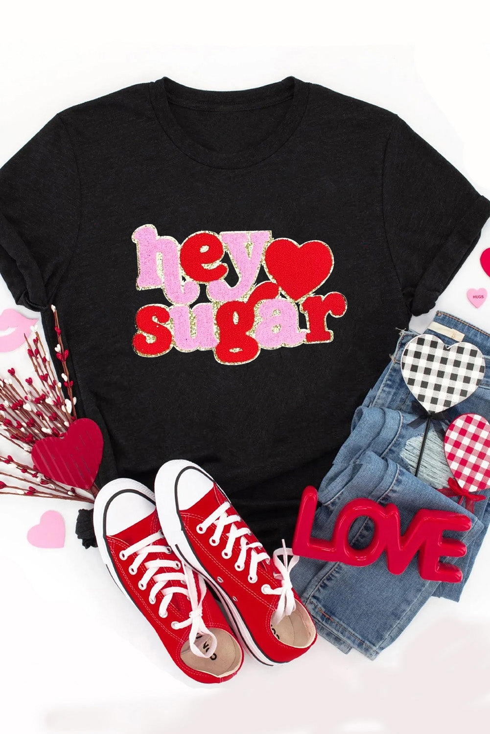 Flat lay of Black Chenille Heart hey sugar Patched Crewneck Valentines Tee styled with red sneakers and denim shorts, perfect for casual Valentine's Day outfits.