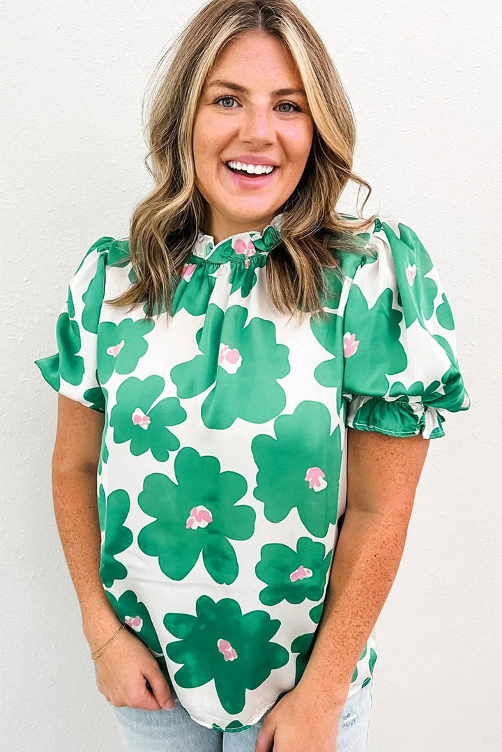 a woman wearing a green and white flower blouse