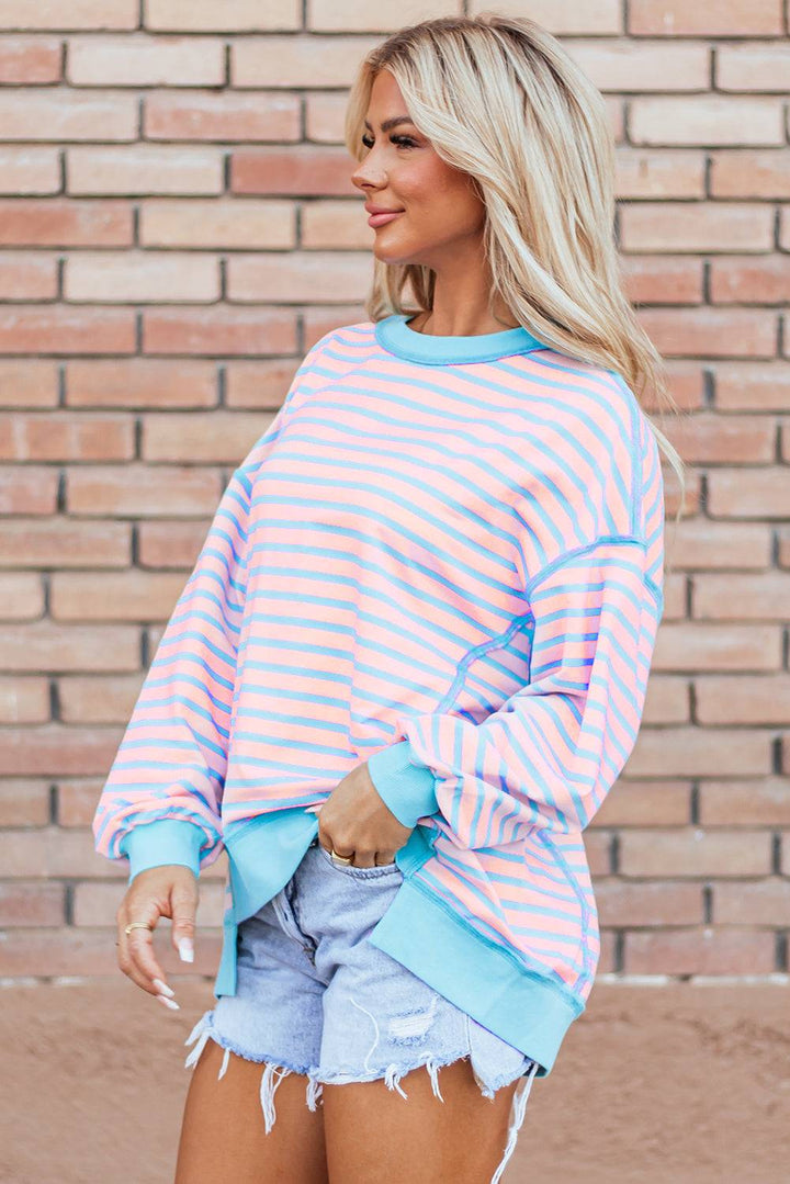 a woman wearing a pink and blue striped sweater