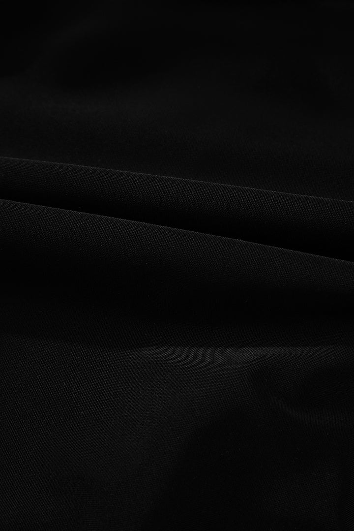 Fabric texture close-up of solid black material used in the 2-tone Crossed Cutout Backless Monokini, soft and stretchable.