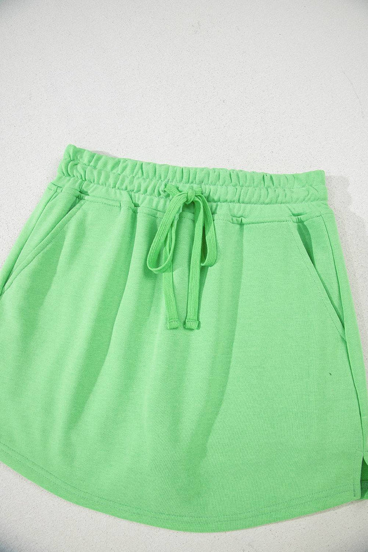 Close-up flat lay of light green French Terry mini skort with drawstring and pockets, ideal for casual comfort from Faith & Co. Boutique.