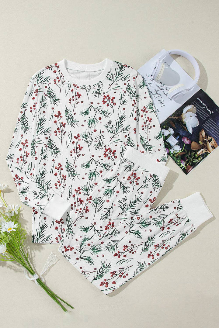 a white shirt with red berries on it next to a bouquet of flowers