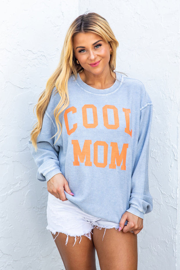 a woman wearing a blue sweater that says cool mom