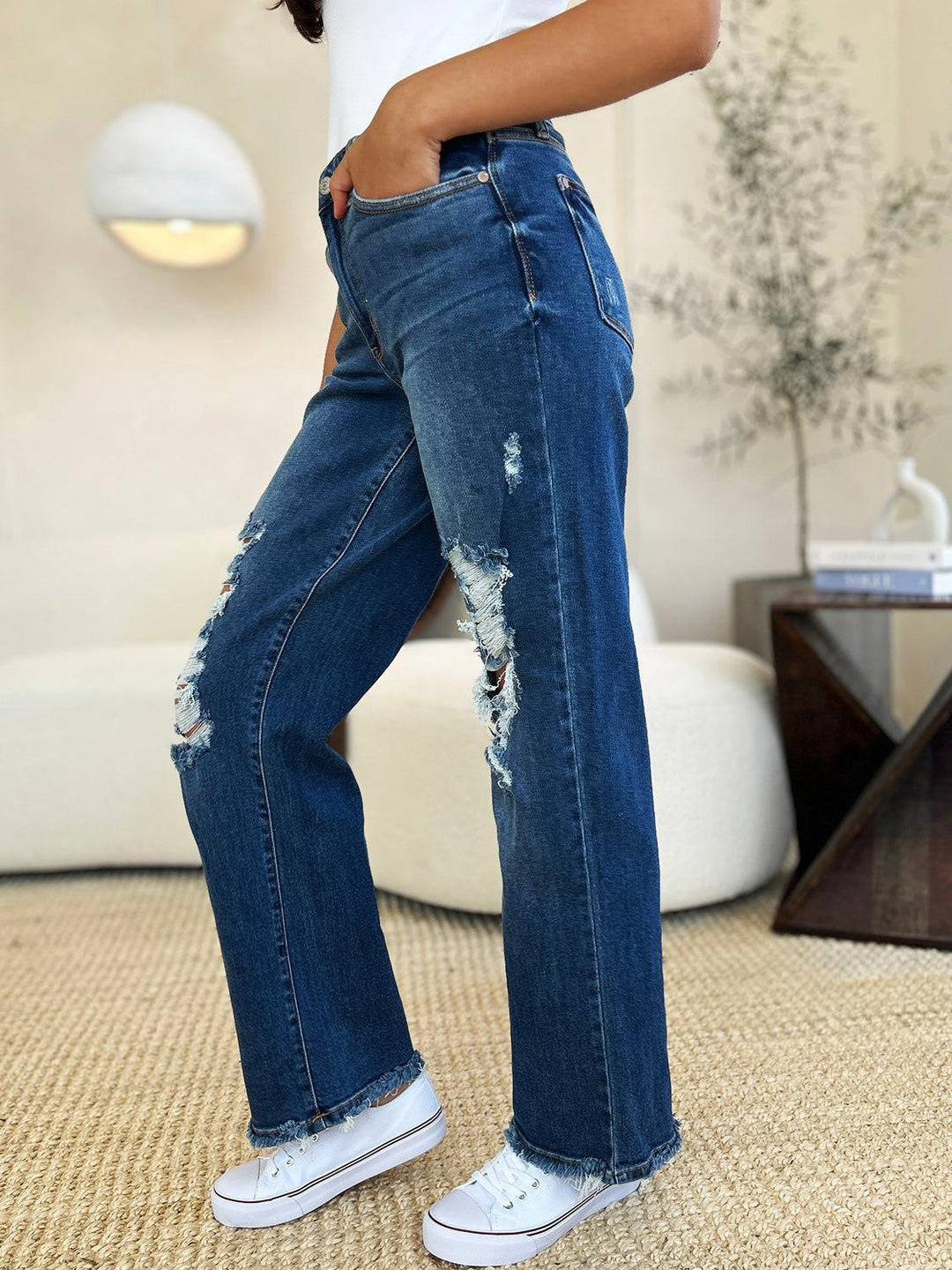 a woman in white shirt and jeans standing in a room