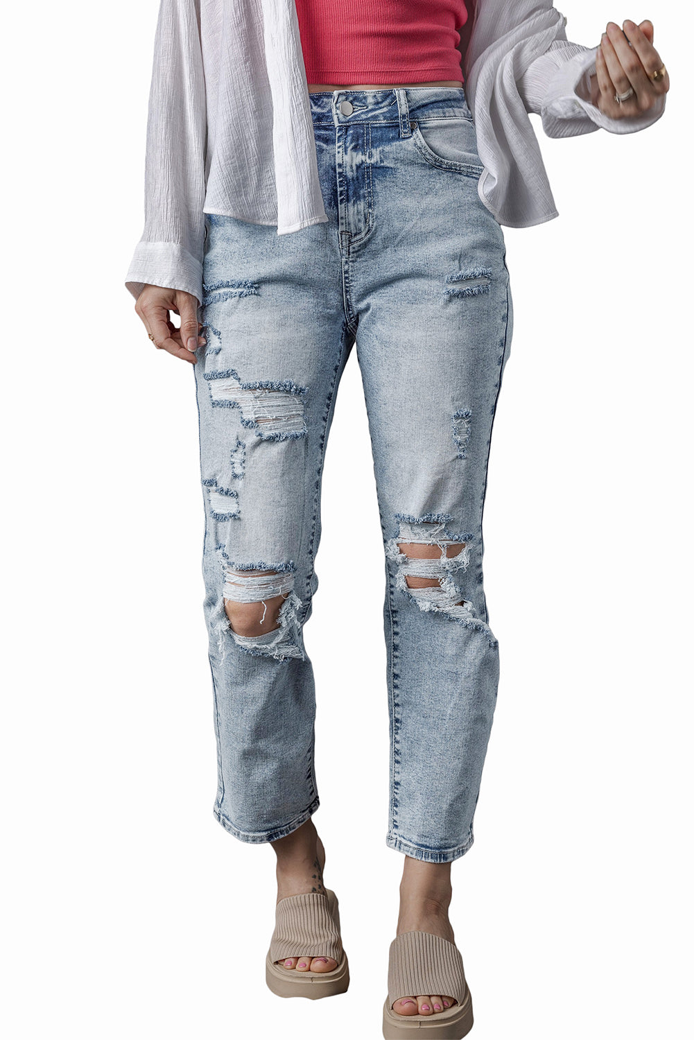 a woman wearing ripped jeans and a white cardigan