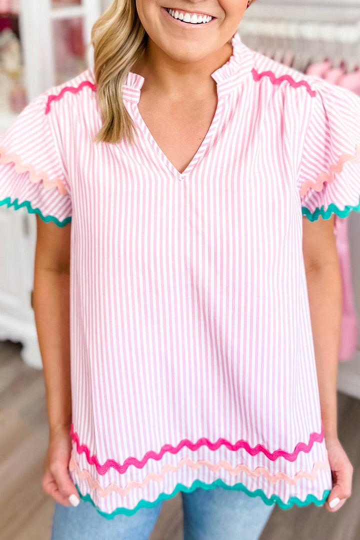 a woman wearing a pink and white striped top