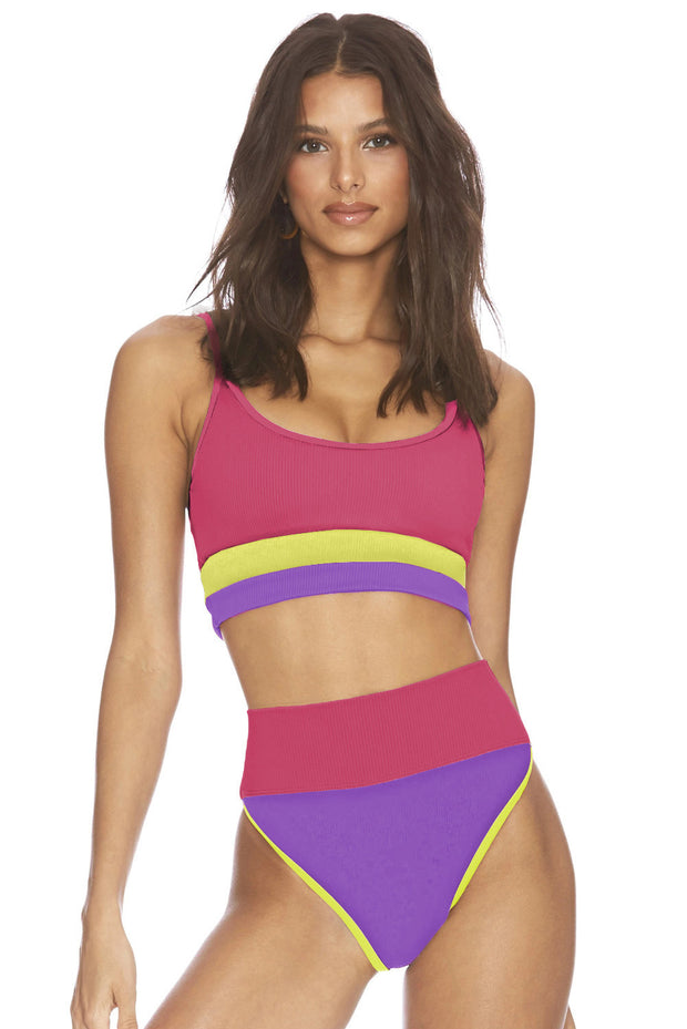 a woman in a pink and purple one piece swimsuit