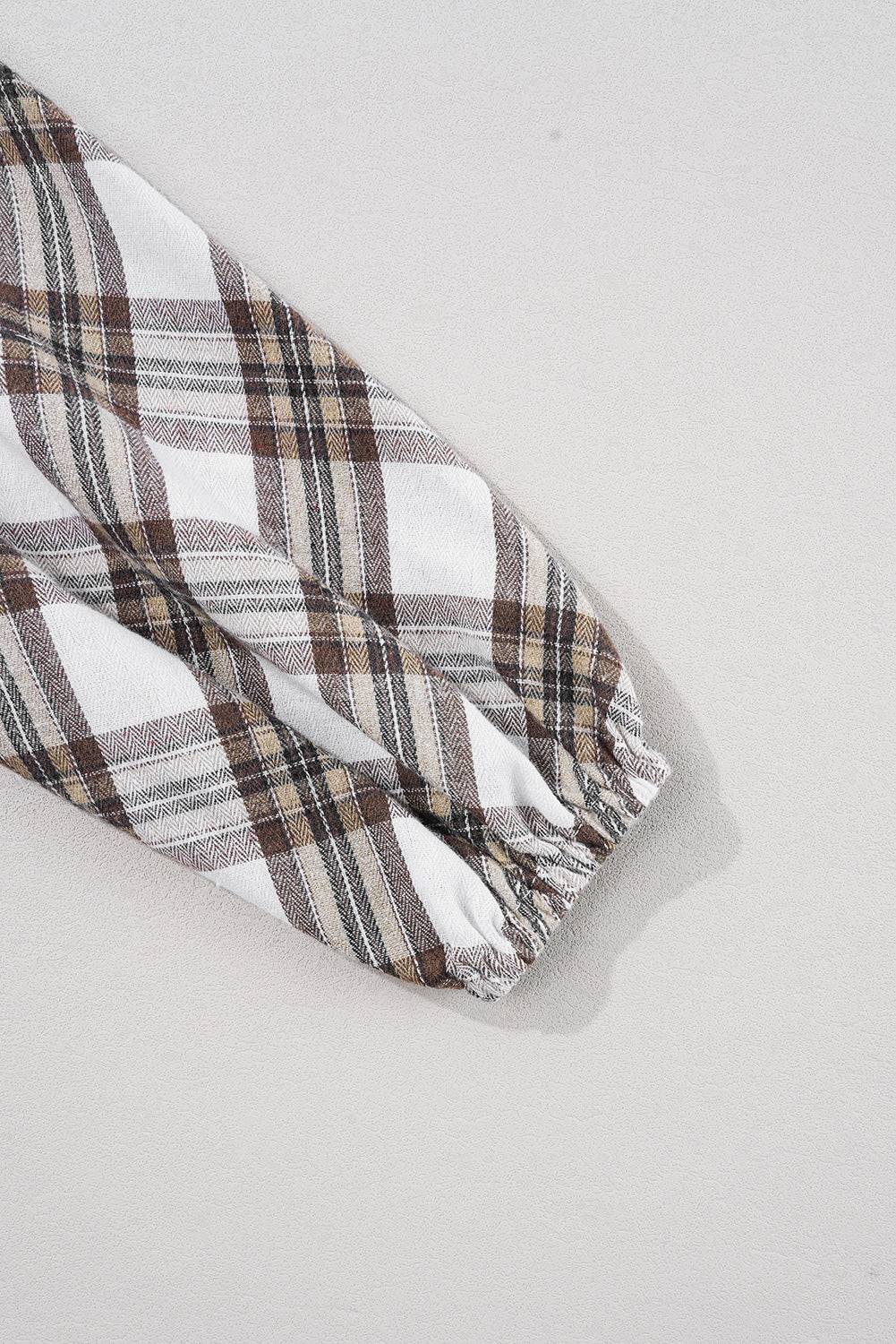 a brown and white checkered scarf laying on top of a white surface