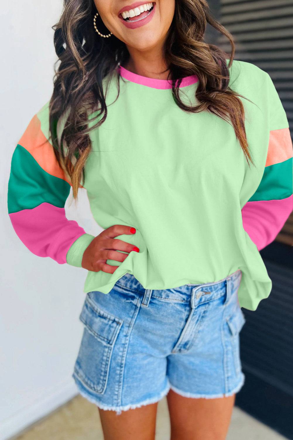 a woman wearing a green and pink top