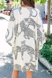 a woman wearing a white and black leopard print dress