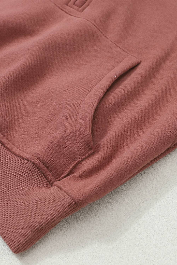 a close up of a pink sweatshirt on a white surface