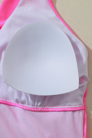 a woman's pink swimsuit with a white plate on it