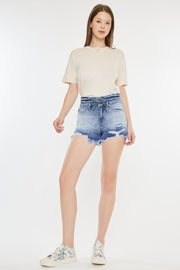 a woman in a white t - shirt and denim shorts