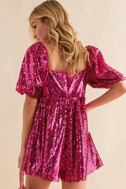 a woman in a pink sequin romper