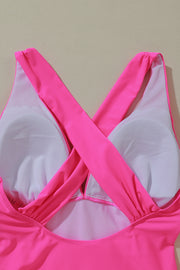 a pink sports bra with a cross strap