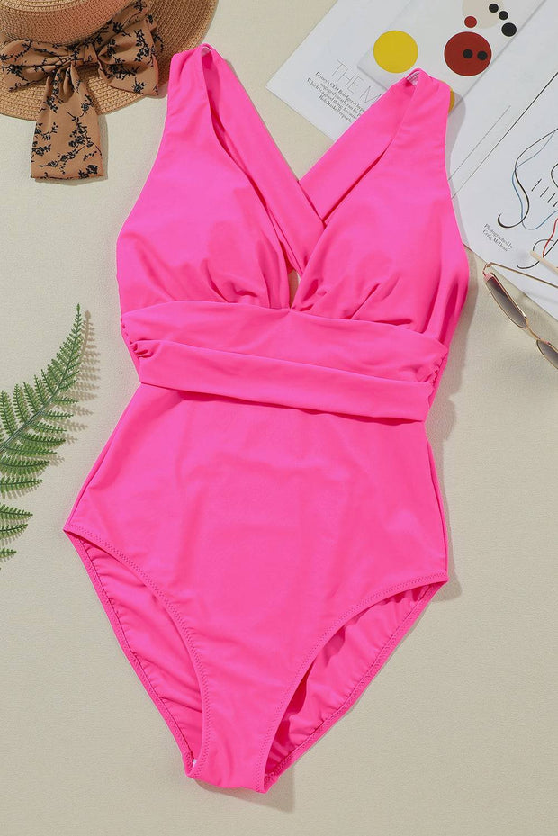 a pink one piece swimsuit sitting on top of a table