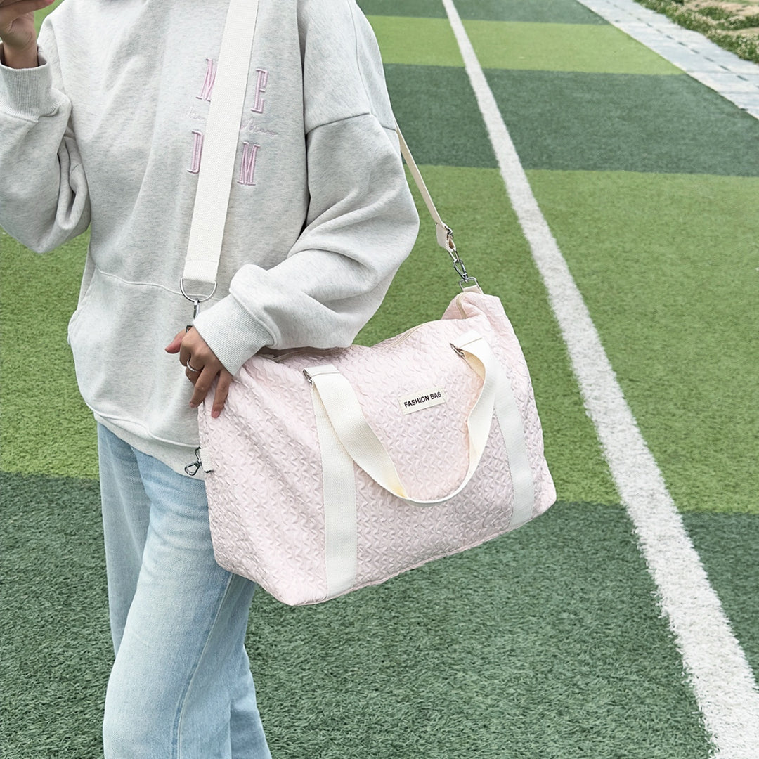 a woman holding a pink purse on a tennis court