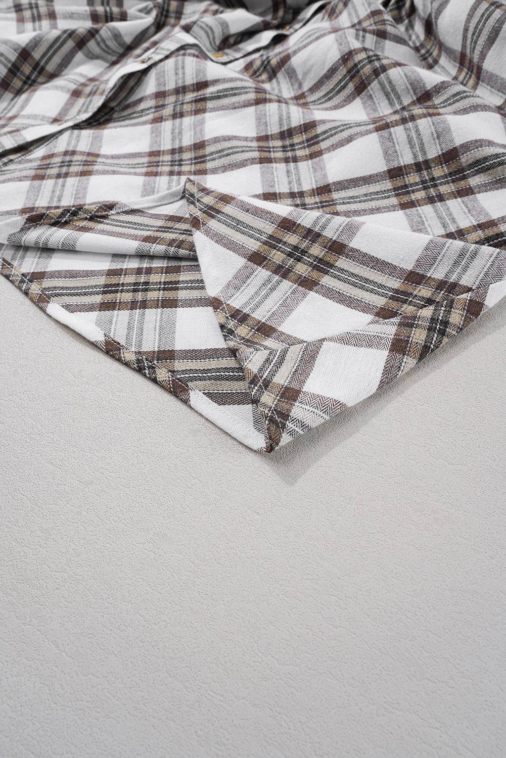 a white and brown checkered shirt laying on a white surface