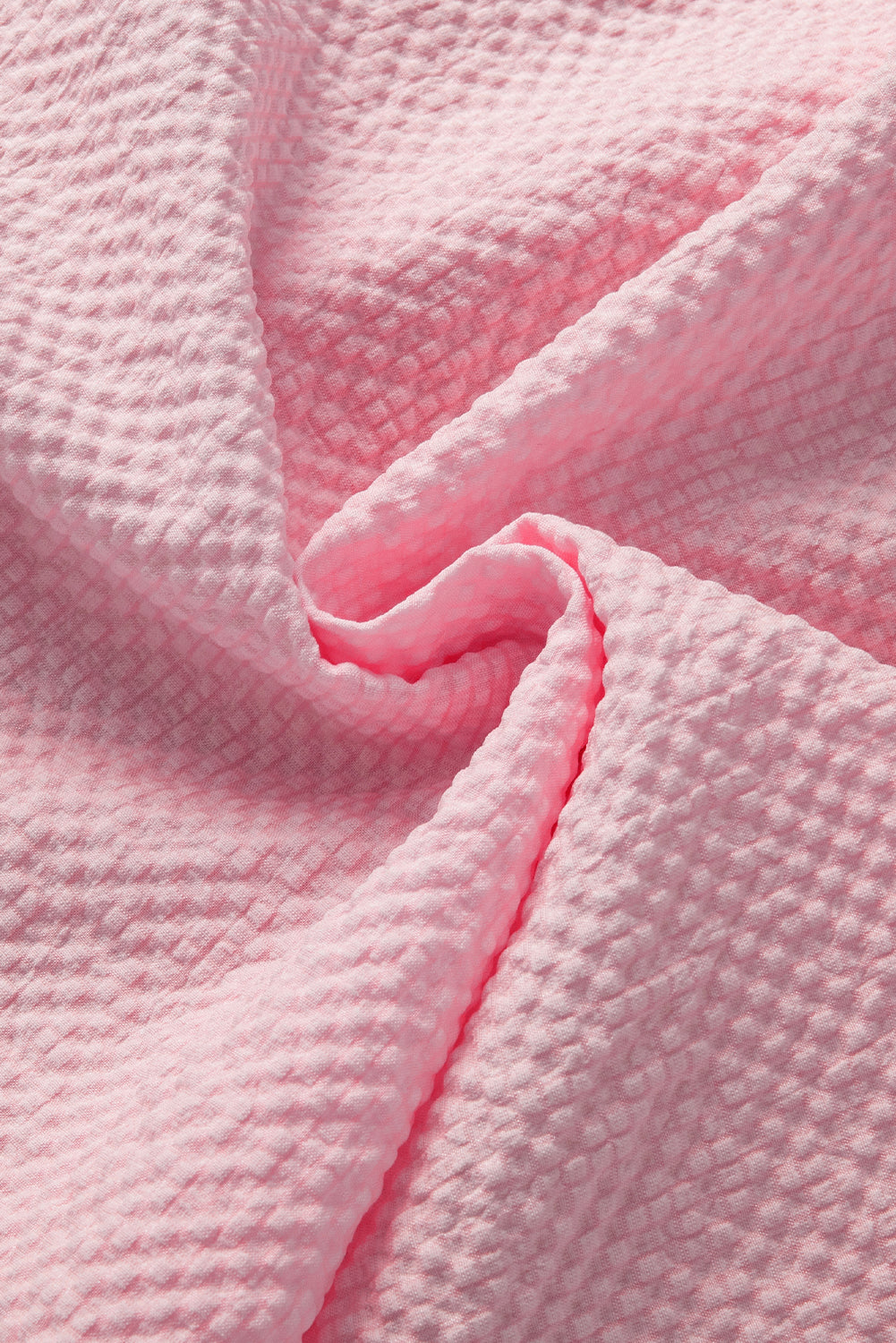 a close up of a pink blanket on a bed