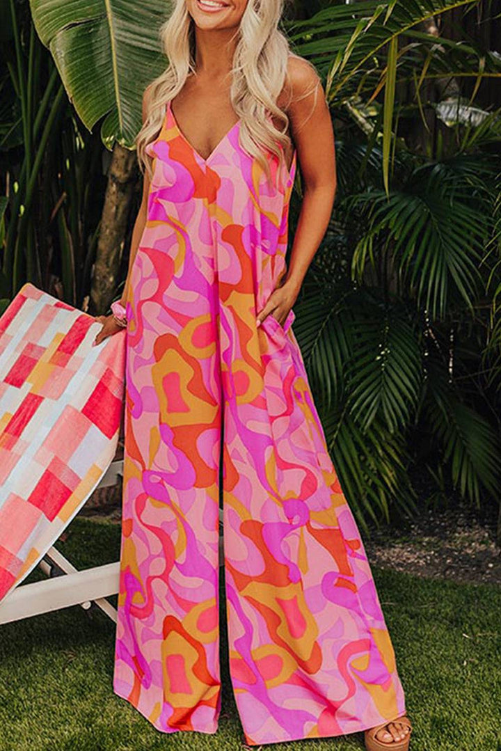 a woman in a pink and orange patterned jumpsuit