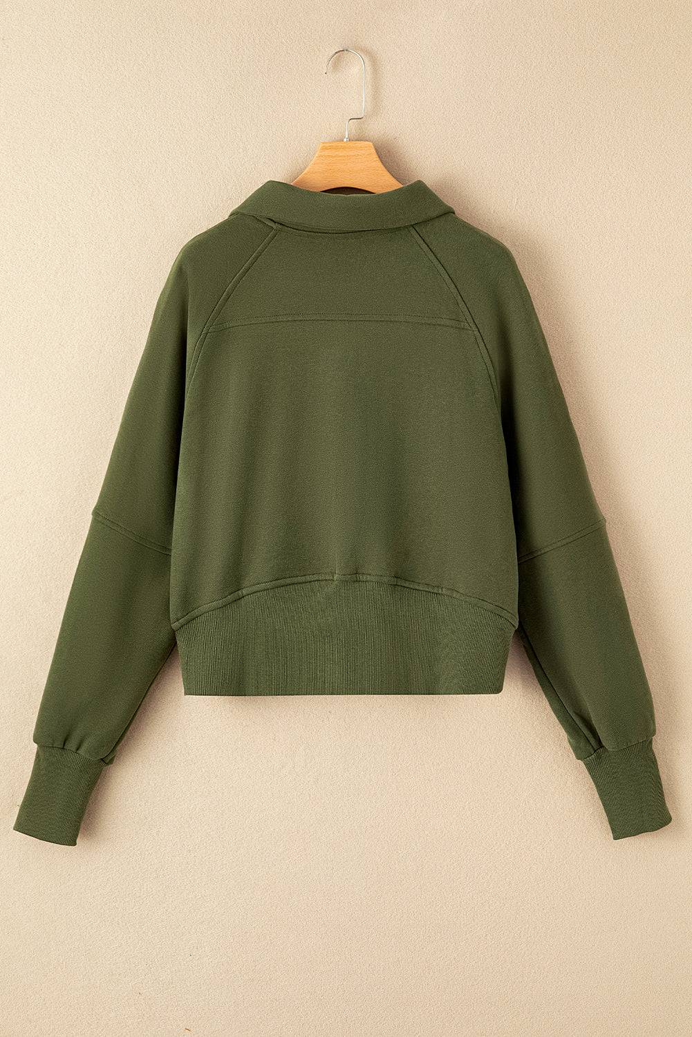 a green sweatshirt hanging on a wall