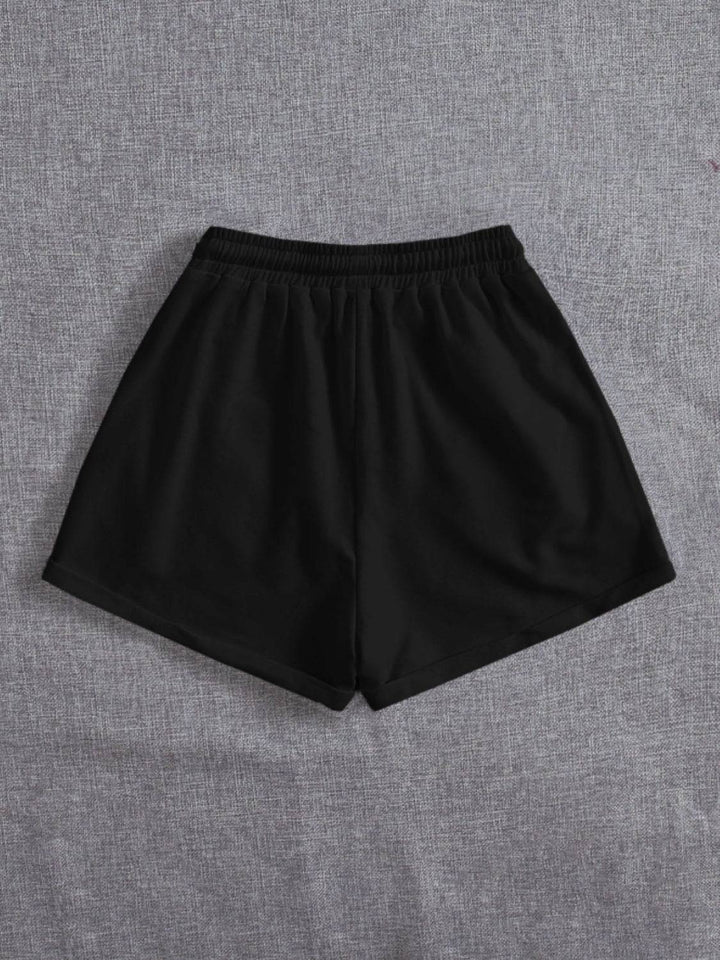 a pair of black shorts sitting on top of a bed