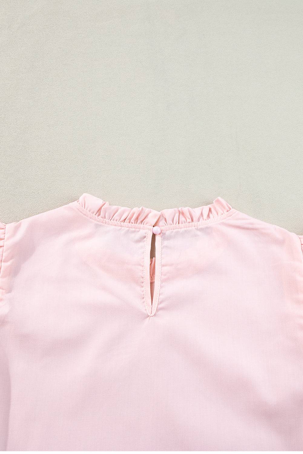 a close up of a pink shirt on a white surface