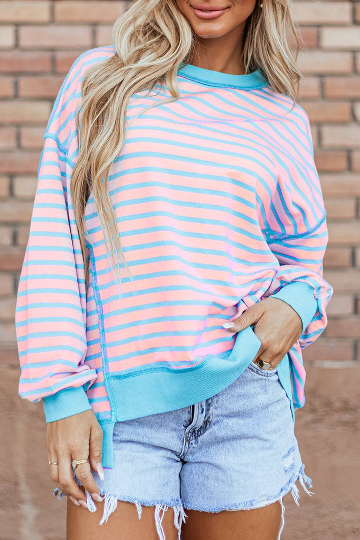 a woman wearing a pink and blue striped sweater