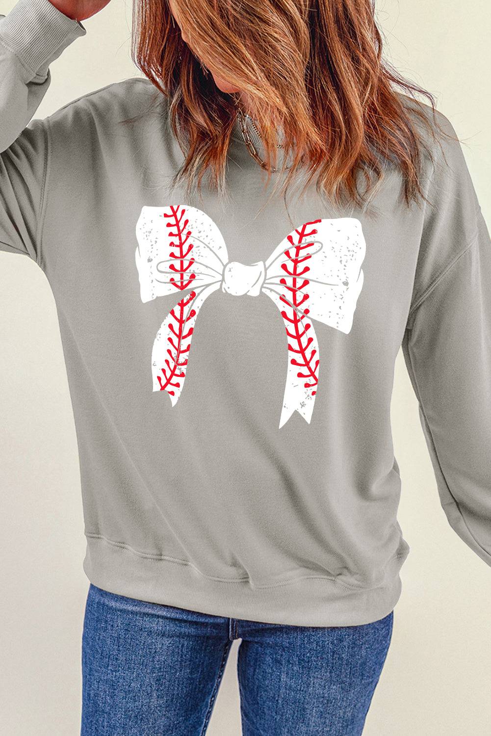 a woman wearing a baseball bow tie sweatshirt