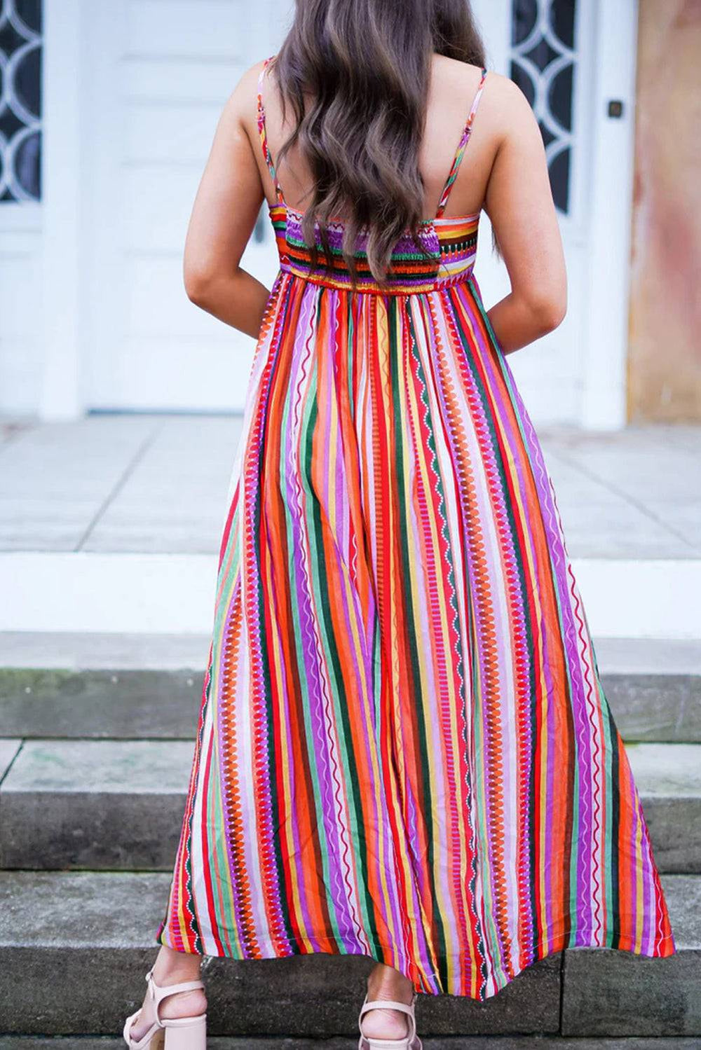 a woman standing on steps wearing a colorful dress