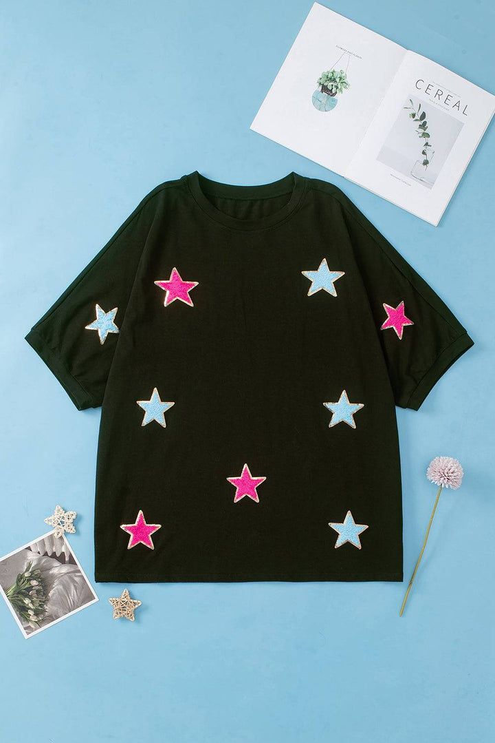 a black t - shirt with pink and white stars on it