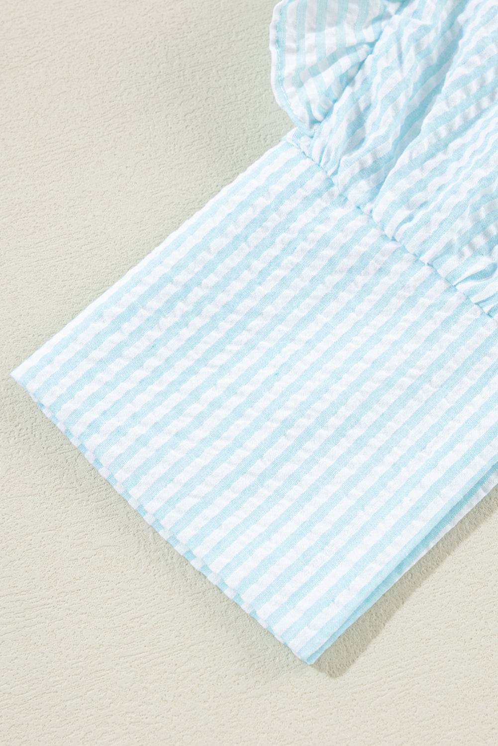 a blue and white striped shirt laying on top of a bed