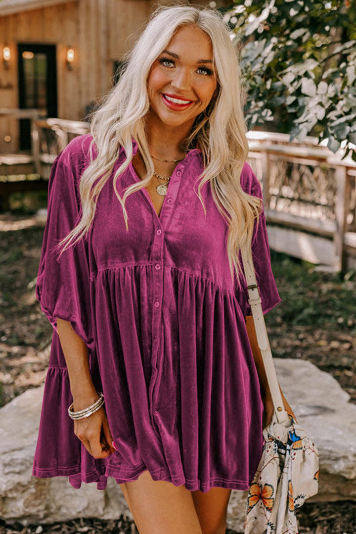 a woman in a purple dress smiling and holding a handbag