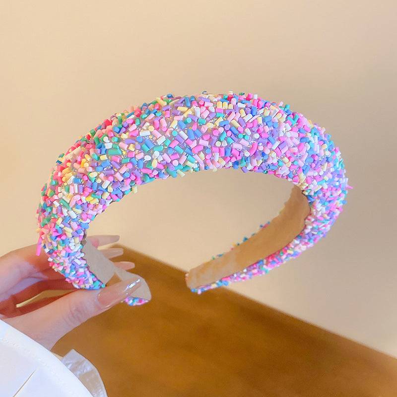 a person holding a fake donut with sprinkles on it