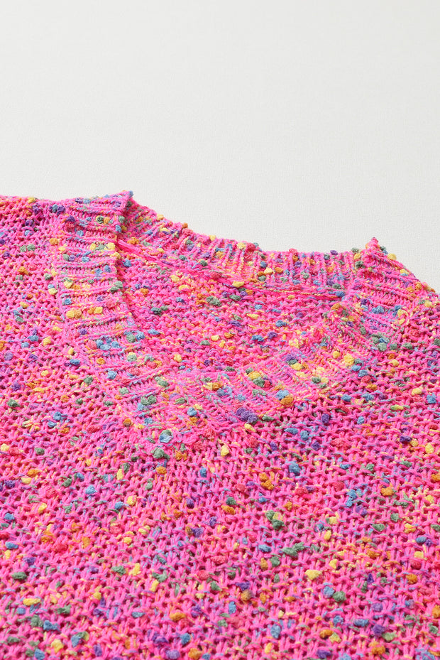 a pink sweater with multicolored dots on it