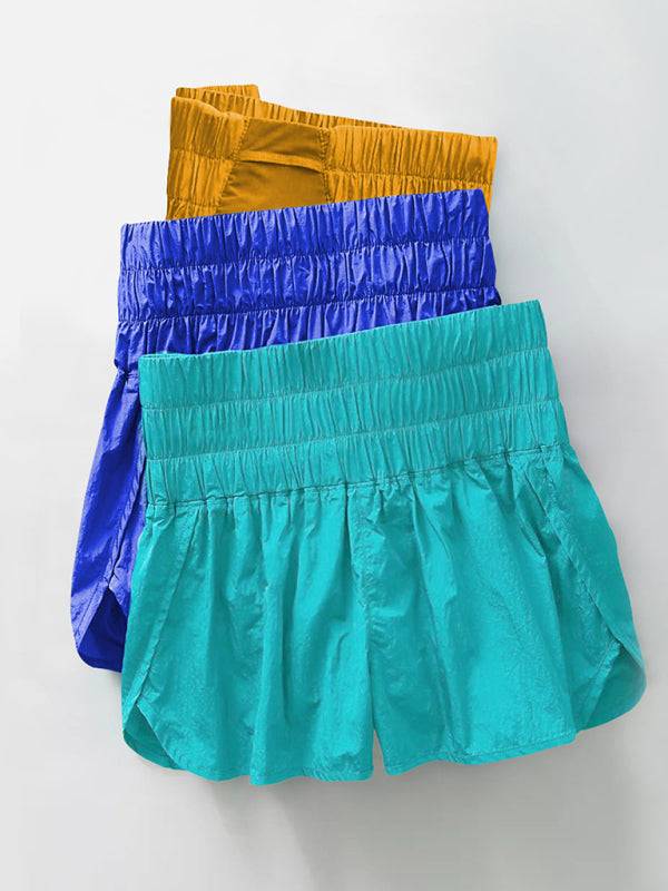 a group of three different colored shorts hanging on a wall
