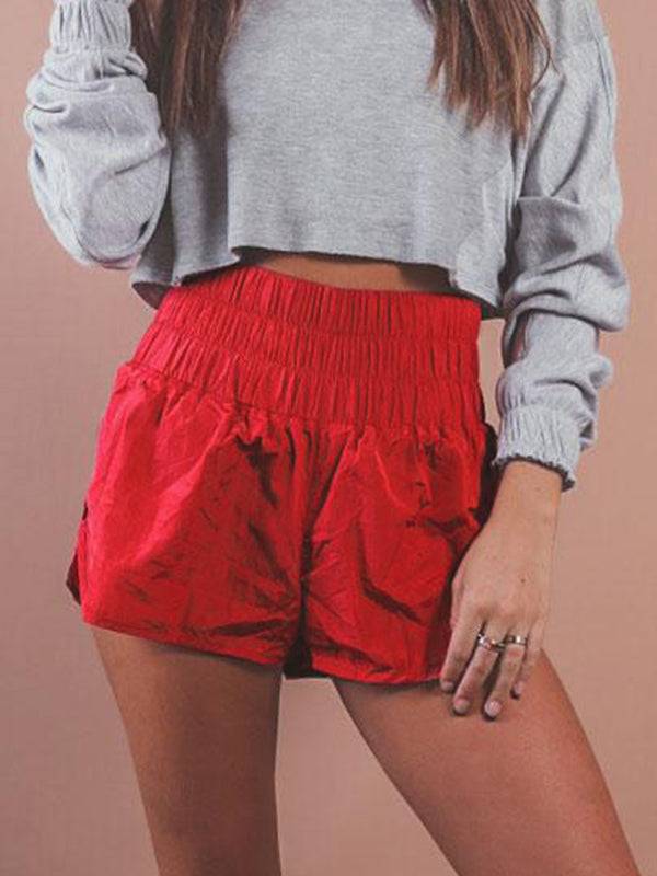 a woman in a grey top and red shorts