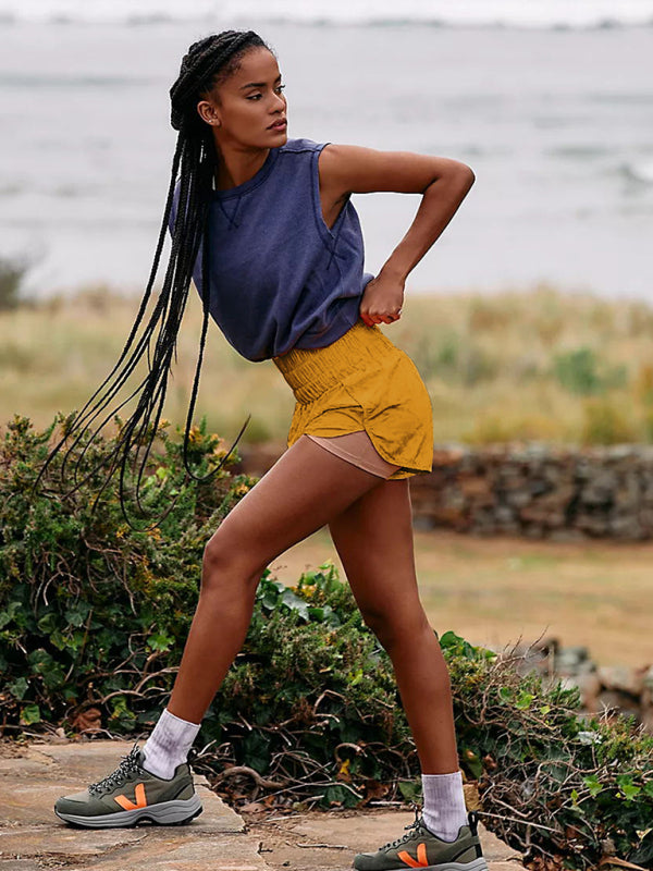 a woman in a blue shirt and yellow shorts