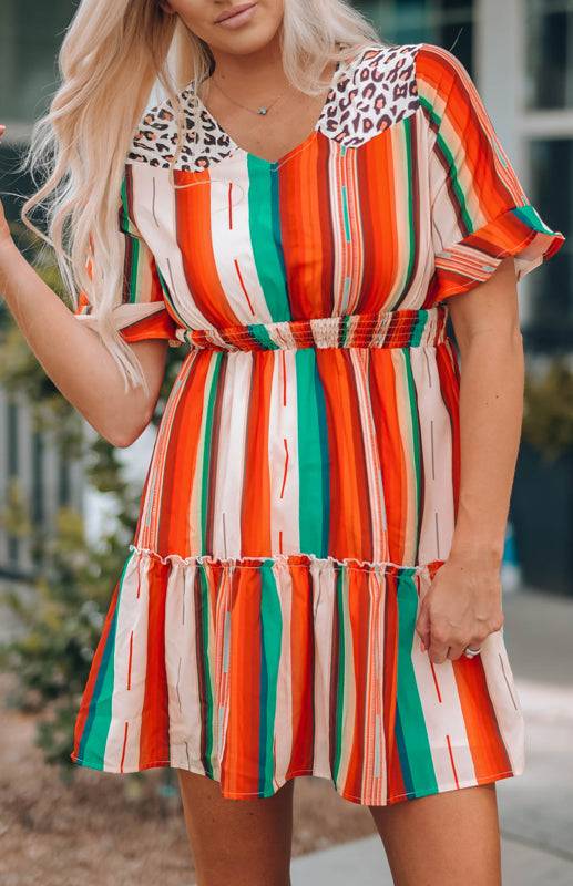 a woman in an orange, green, and white striped dress