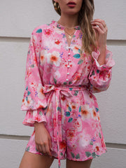 a woman in a pink floral romper and hat